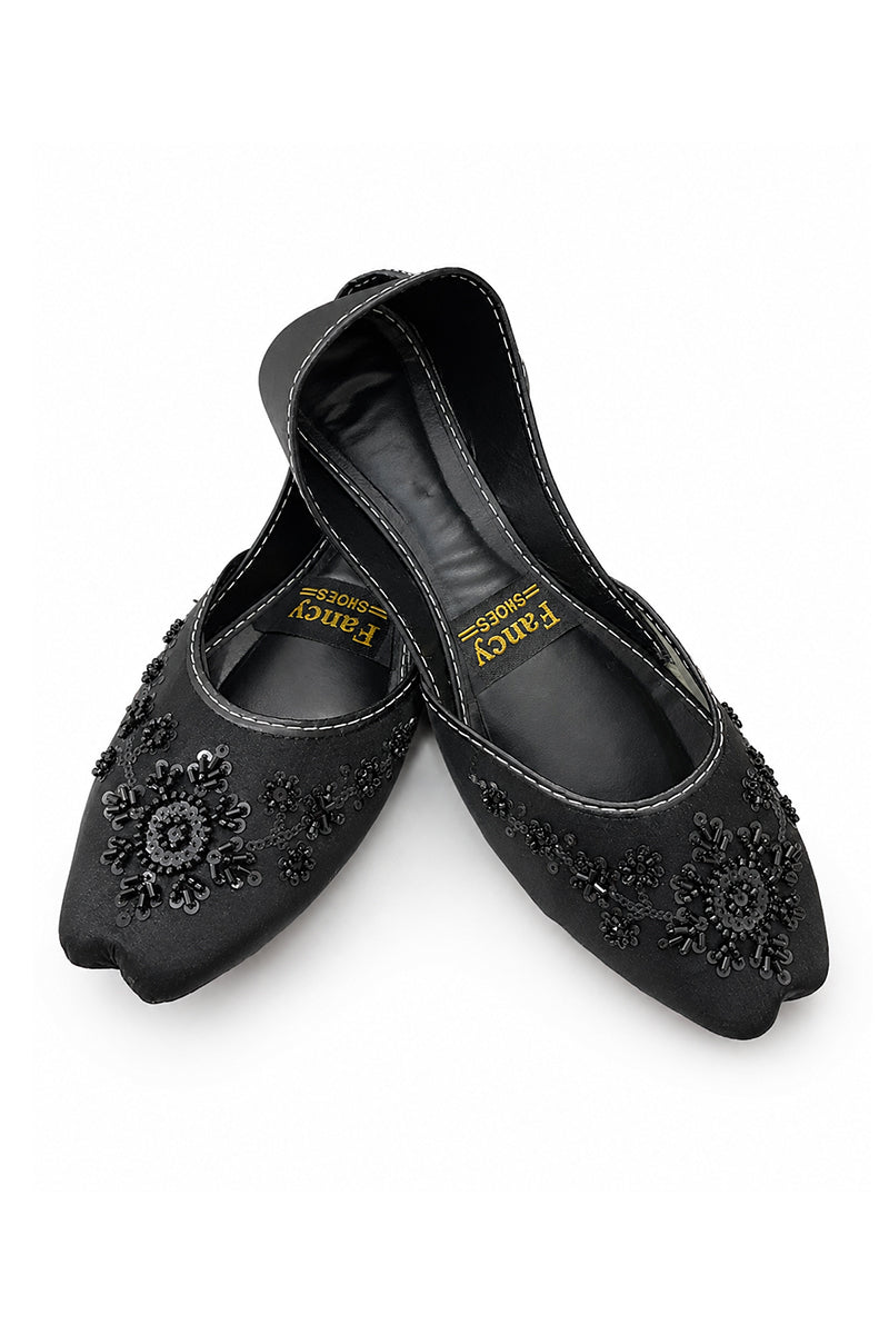 A pair of black pointed-toe flats with floral embroidered details on the toe, shown on a white background. The brand name 'Fancy' is visible on the insole.