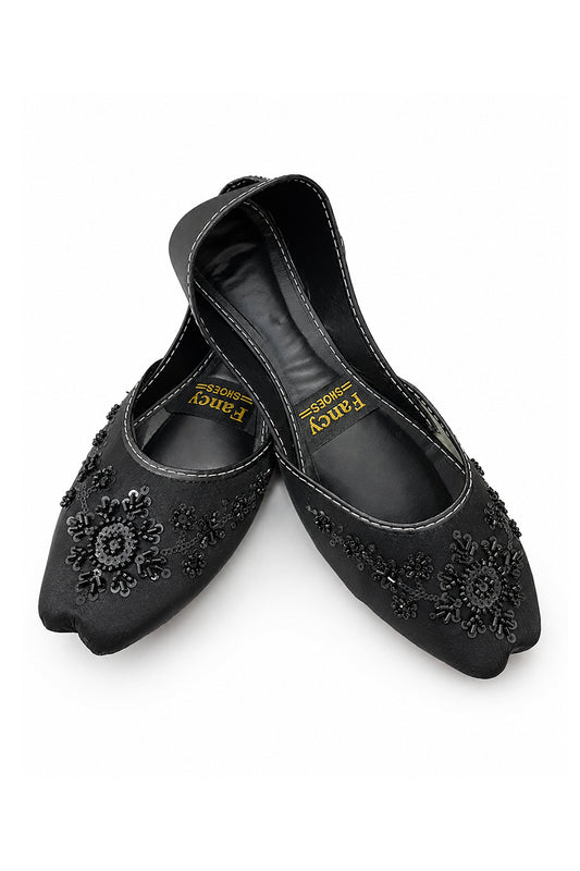 A pair of black pointed-toe flats with floral embroidered details on the toe, shown on a white background. The brand name 'Fancy' is visible on the insole.